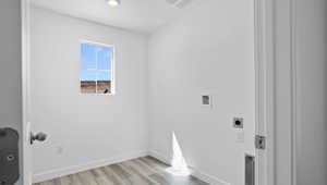 Laundry room featuring hookup for an electric dryer, light wood-type flooring, baseboards, and hookup for a washing machine