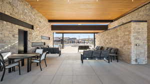 View of patio / terrace with an outdoor living space with a fireplace and outdoor dining area