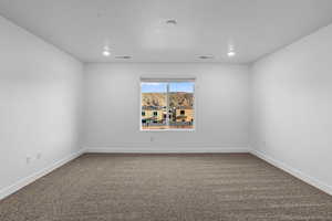Unfurnished room featuring carpet flooring, baseboards, and recessed lighting