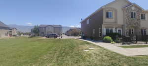 View of home's exterior with stucco siding, a mountain view, stone siding, a residential view, and cooling unit