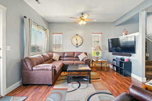 Living area featuring wood finished floors, ceiling fan, and baseboards