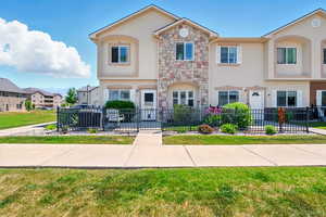 Townhome / multi-family property with stucco siding and stone siding