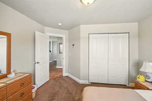 Carpeted bedroom with baseboards and a closet