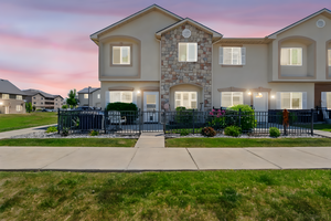 Townhome / multi-family property featuring stucco siding and stone siding