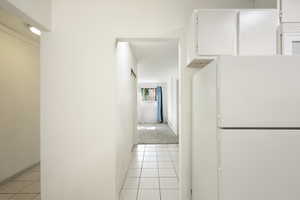 Corridor featuring light tile patterned floors