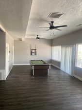 Playroom featuring a textured ceiling, baseboards, dark wood-type flooring, pool table, and a ceiling fan
