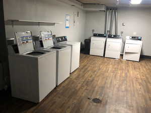 Shared laundry room featuring washer and dryer and dark wood-type flooring
