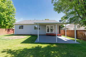 Rear view of house featuring a patio and roof with shingles