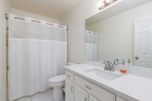 Bathroom with vanity, toilet, and tile patterned floors