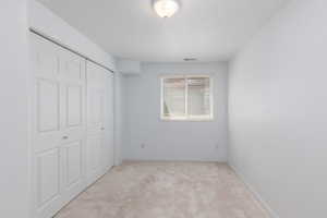 Unfurnished bedroom with carpet flooring, a closet, and baseboards