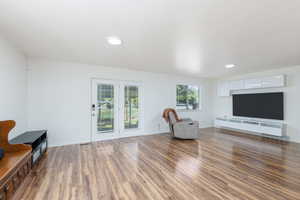 Living area with wood finished floors, baseboards, and recessed lighting