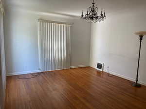 Living room featuring a chandelier, baseboards, and wood finished floors