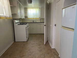 Kitchen with white gas range oven, refrigerator, open shelves, backsplash, and a sink