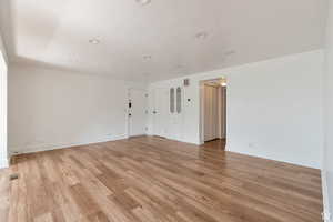 Empty room featuring light wood-type flooring, baseboards, and recessed lighting