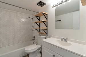 Bathroom with toilet, vanity, and bathing tub / shower combination