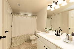 Bathroom featuring vanity, toilet, tile patterned flooring, and a shower with shower curtain