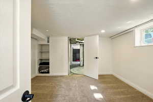 Unfurnished bedroom featuring carpet, baseboards, recessed lighting, and a textured ceiling
