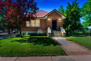 View of front of home featuring brick siding and metal roof