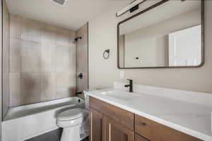 Bathroom featuring toilet, vanity, bathtub / shower combination, and tile patterned flooring