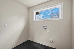 Laundry room featuring washer hookup and dark tile patterned floors