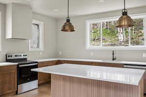 Kitchen with stainless steel range with electric cooktop, a sink, light wood-type flooring, dishwashing machine, and brown cabinetry