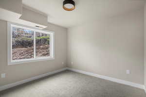 Carpeted empty room featuring baseboards