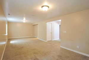 Spare room featuring light carpet and baseboards