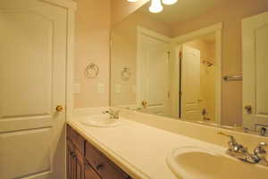 Full bathroom with double vanity and a shower