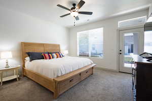 Carpeted bedroom featuring ceiling fan, baseboards, and access to exterior
