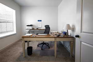 Home office with carpet and baseboards