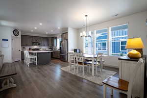 Dining room with a chandelier, recessed lighting, baseboards, and dark wood finished floors