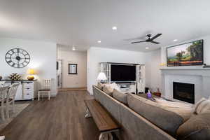 Living area with wood finished floors, recessed lighting, a brick fireplace, ceiling fan, and baseboards