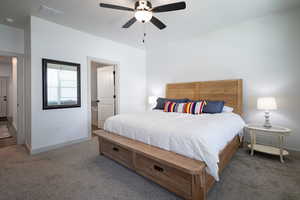Carpeted bedroom featuring baseboards and ceiling fan