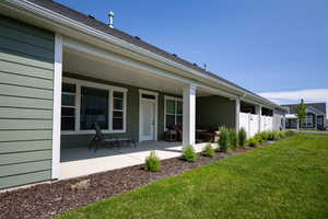 Rear view of property with a yard and a patio area