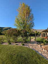 View of green lawn featuring a mountain view and a playground
