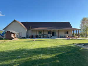 Rear view of house featuring a patio and a lawn