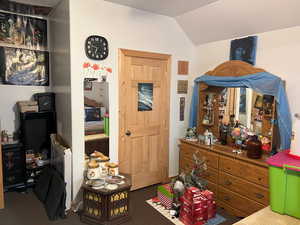Carpeted bedroom with lofted ceiling