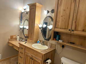 Half bathroom featuring toilet, vanity, and tile patterned flooring