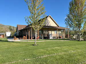 Back of house with a yard, a patio area, and a mountain view