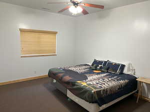 Bedroom featuring carpet floors, baseboards, and ceiling fan