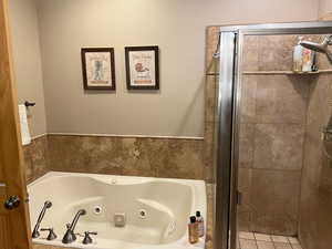 Full bath featuring a tub with jets and a shower stall
