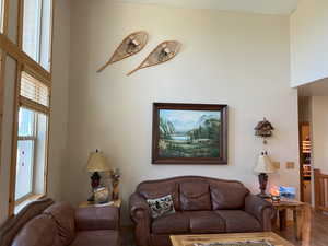 Living area featuring wood finished floors and a towering ceiling