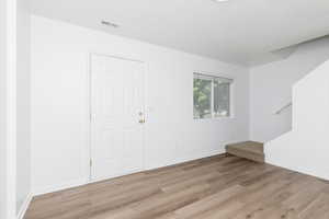 Spare room featuring light wood-type flooring and baseboards