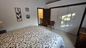 Bedroom featuring light colored carpet and a closet