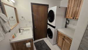Laundry room featuring estacked washer and dryer and a sink
