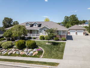 View of front of property with a front lawn, an outbuilding, a garage, and roof with shingles