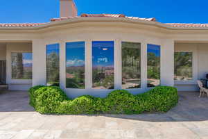 View of property exterior with a tile roof and stucco siding