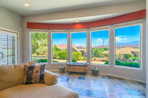 Living area featuring baseboards, stone tile flooring, healthy amount of natural light, recessed lighting, and a mountain view