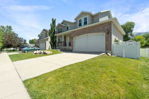 View of front of house with driveway, brick siding, and an attached garage