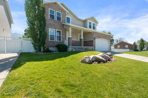 View of front of house with brick siding, driveway, a garage, stucco siding, and a porch